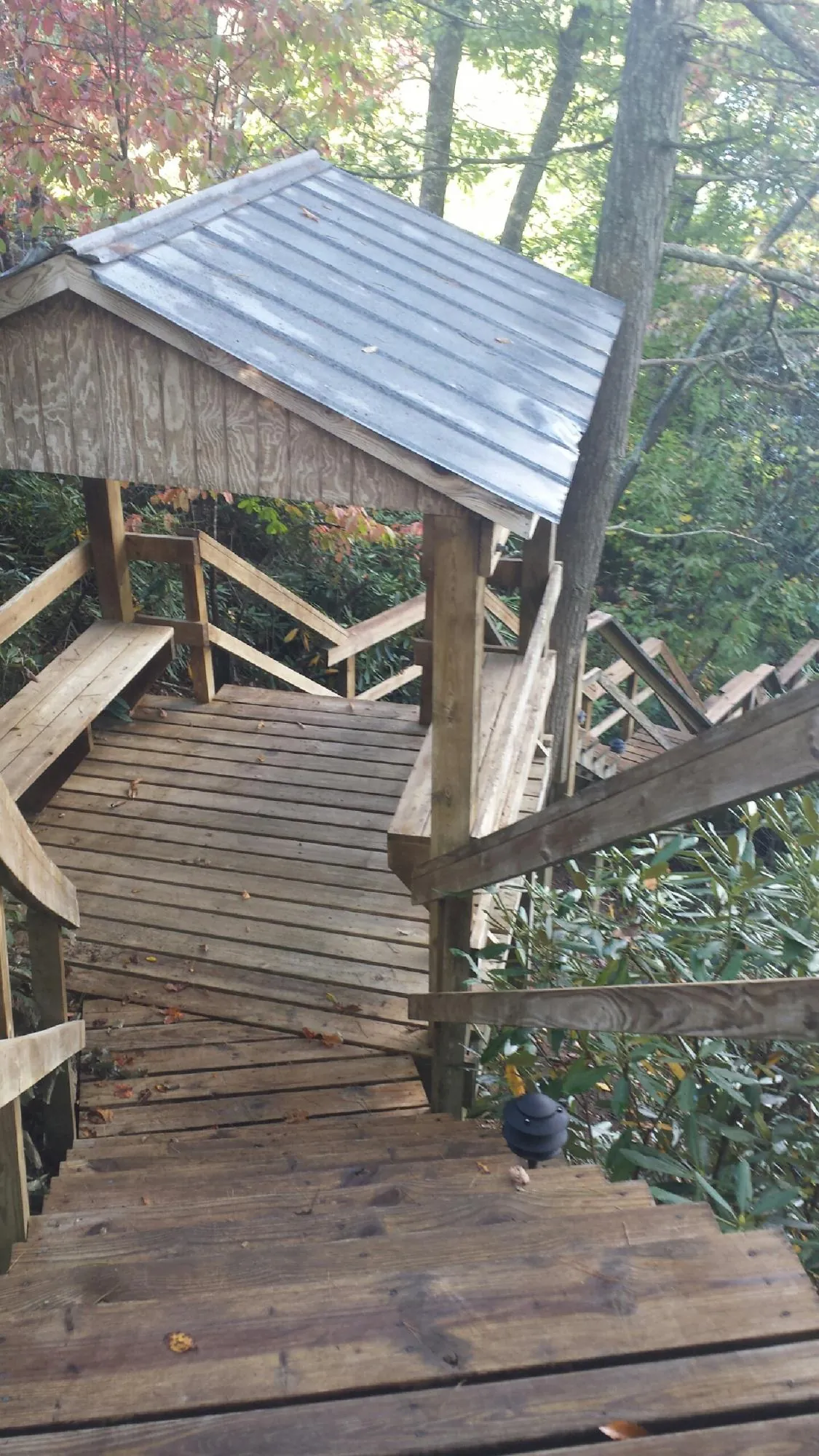 Metal roofed shelter over wooden steps on a wooded walkway — Skylight Repair & Installation work by our crew in Winsted